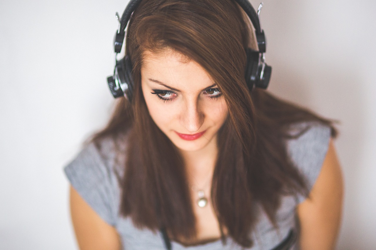 Mulher de headphones estudando para melhorar o listening