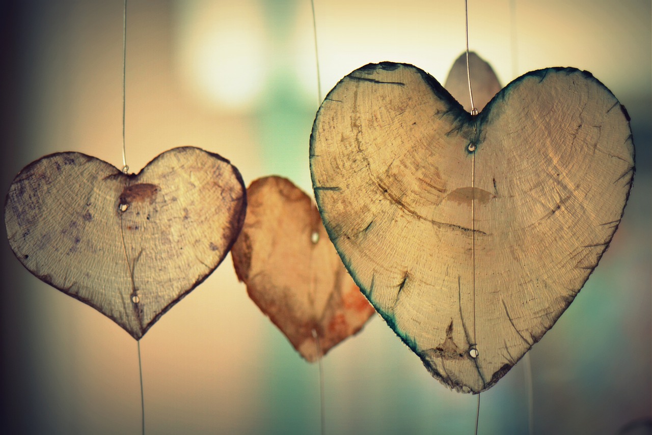 corações de madeira pendurados - imagem do post sobre melhores nomes para colocar no contato do namorado em inglês